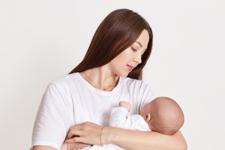 Femme qui tient son bébé dans ses bras